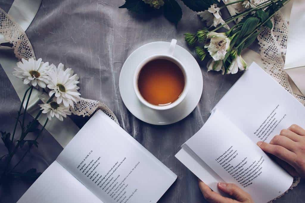 Koronawirus, jak zadbać o siebie i związek? - widok stołu z książką i filiżanką kawy - artykuł Marity Woźny
