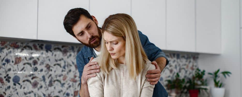 Lęk przed odrzuceniem &ndash; jak sobie z nim radzić - para w trakcie kł&oacute;tni, on chce ją objąć od tyłu, ona jest wycofana, czuje lęk przed odrzuceniem - psychoterapia Marita Woźny